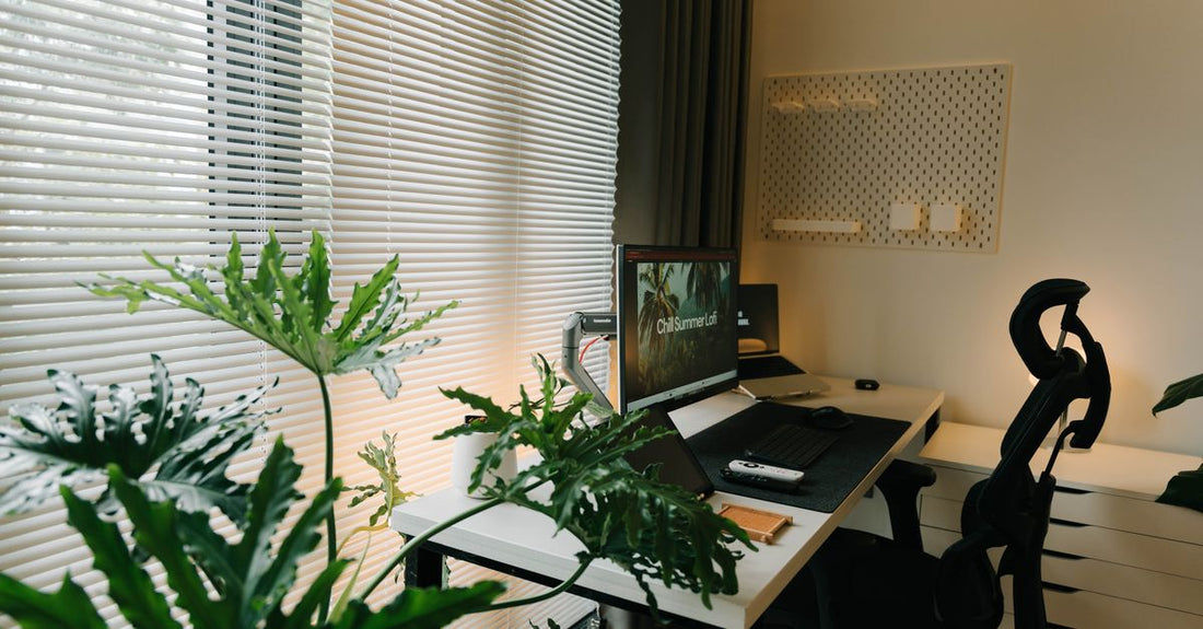 A home office with a desk, chair and plants beside a window