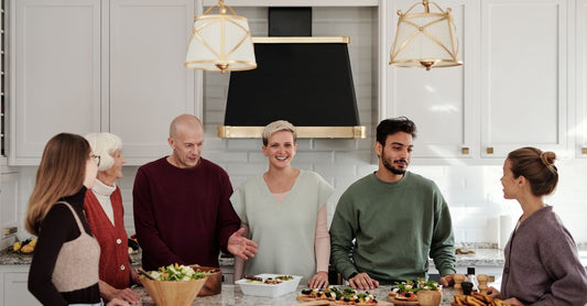A multi-generational family enjoying a meal preparation together in a bright kitchen.