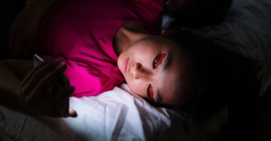 Person using phone in dark bedroom at night